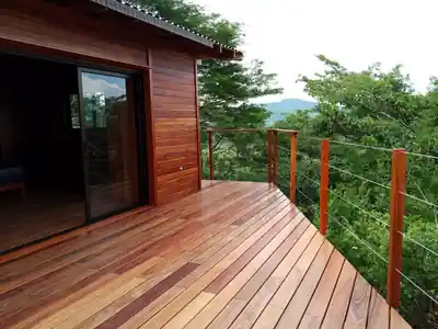 Deck de caoba africana de la cabaña elevada con vista al bosque